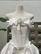 White corset dress on a mannequin against a neutral background